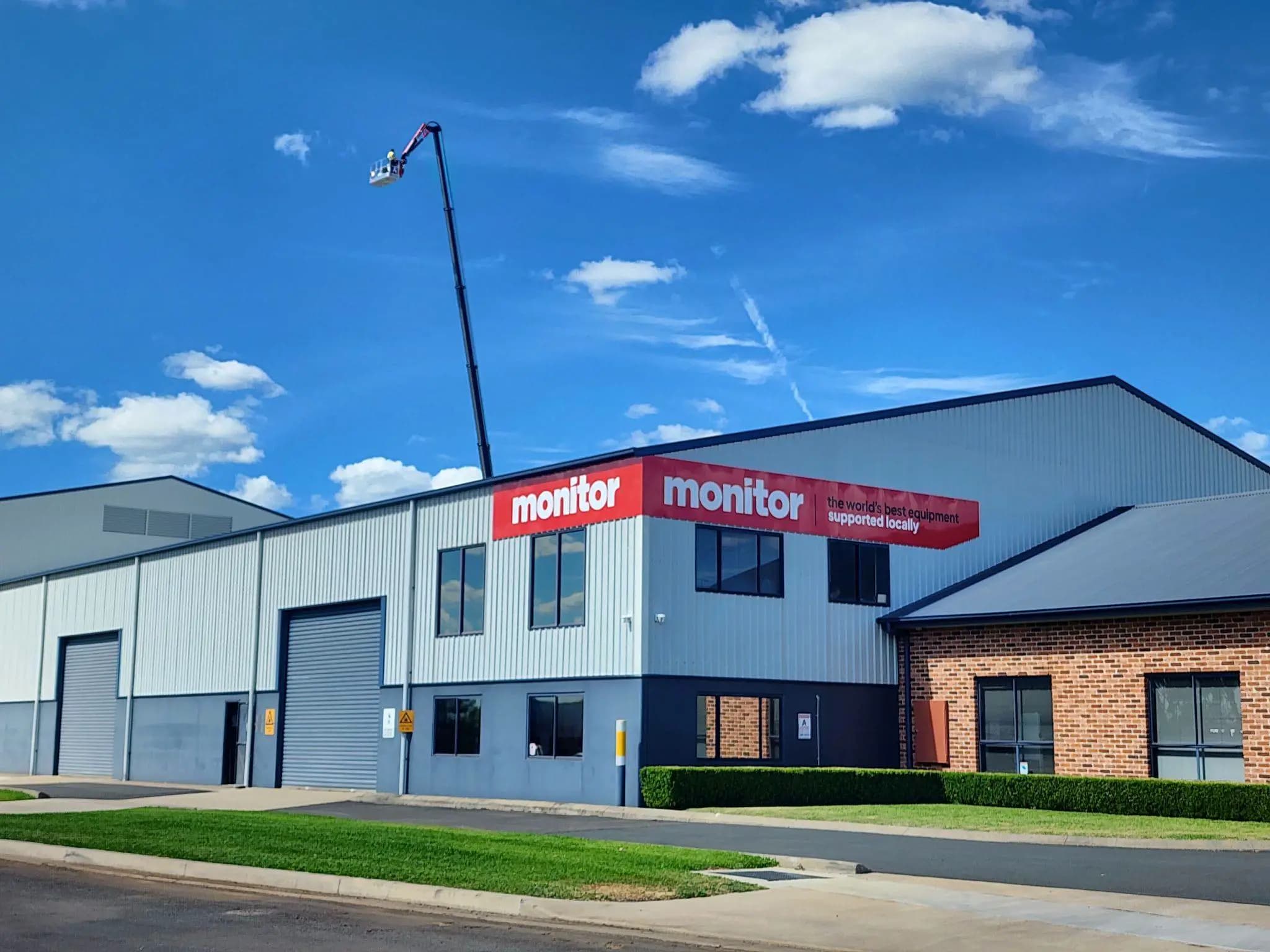 Plataforma elevadora en un edificio con un cartel de monitor al lado.