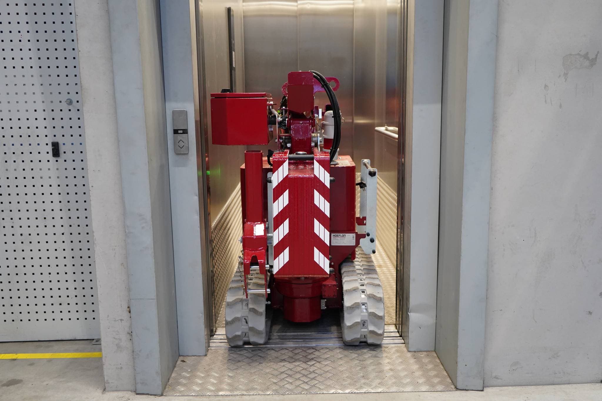 Imagen de la grúa Hoeflon C1e en modo de transporte dentro de un ascensor.