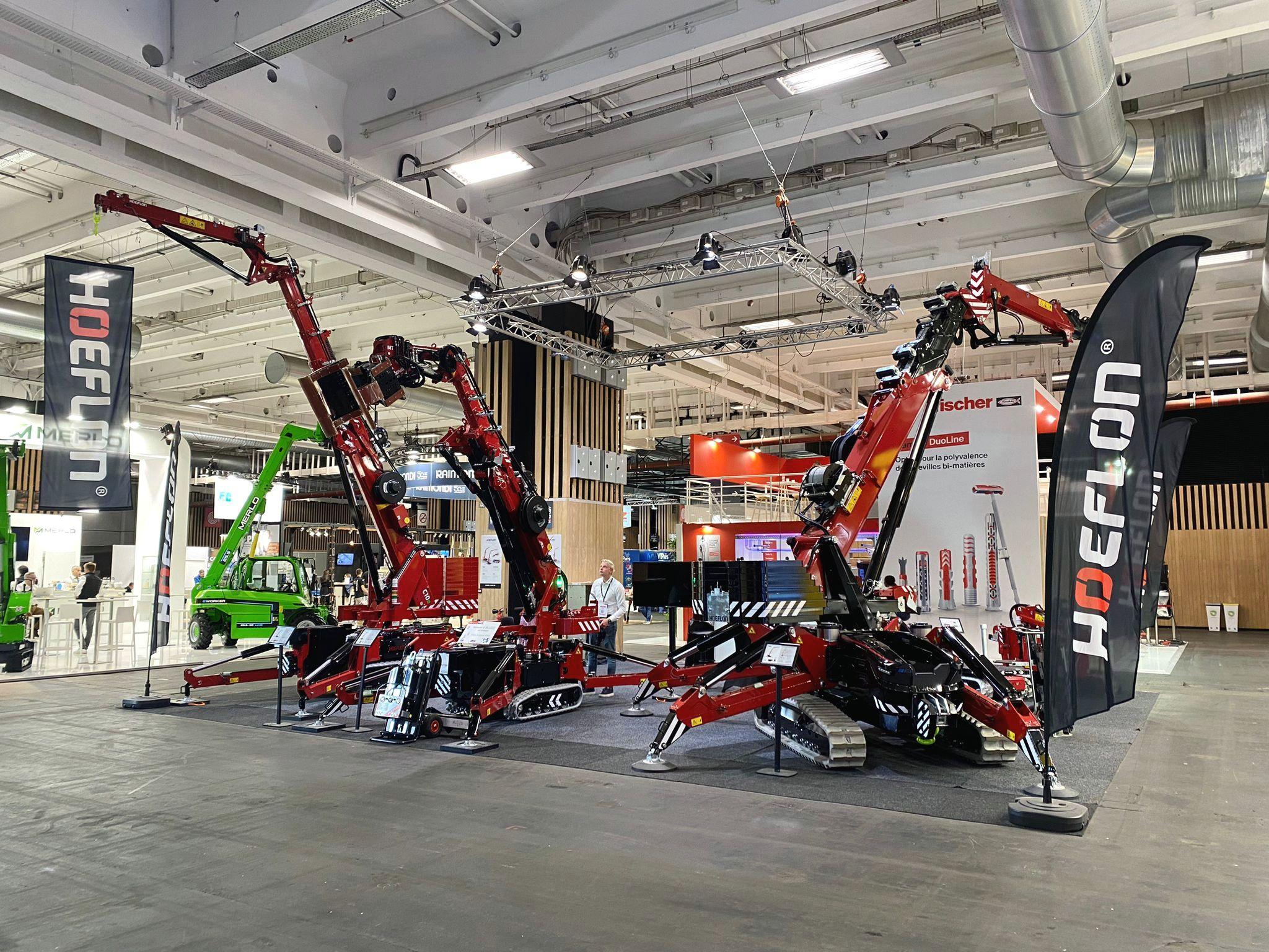 Grúas Hoeflon en un stand de feria durante Batimat 2024.