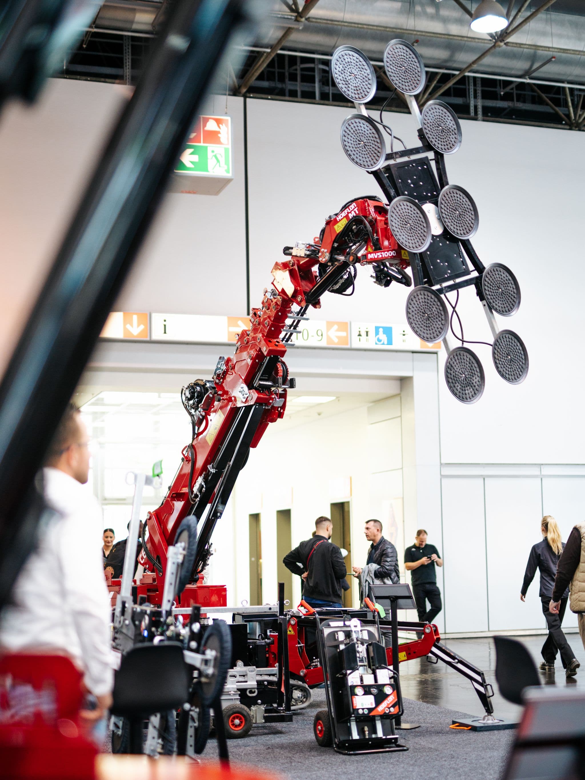 Grúa Hoeflon levantando un objeto con succión en una feria.